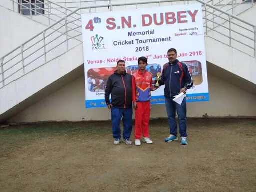 Tournament officials presenting a trophy to a young player at the closing ceremony